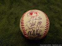 Photo of a side of the official Rawlings Playmaker baseball showing several black ink signatures.