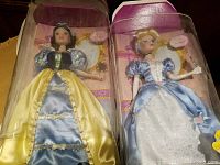 Front view of Snow White and Cinderella dolls in original plastic packaging.