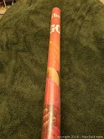 Rolled 1976 Gone With The Wind poster displayed on a green fabric background, showing part of the colorful artwork visible on the side of the roll.