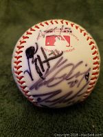 Front view of the baseball showing the MLB logo and several autographs.