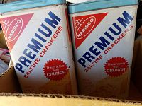 Photo showing two vintage Nabisco Premium Saltine Crackers metal tins with original branding and some dust.