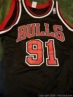 Front view of black Chicago Bulls basketball jersey with number 91 in red and white, with NBA logo patch
