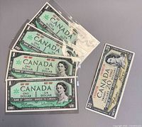 Group view of one $20 and four $1 Canadian banknotes