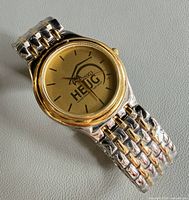 Close-up of dial showing HEUG 2003 logo and gold bezel