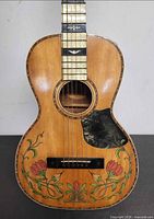 Front view of entire Regal parlor guitar showing floral decal and overall body