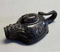Top view of carved stone teapot showing turtle shell pattern, lid and handle
