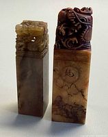 Two soapstone seals side by side showing overall form and carvings