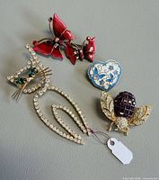 Group shot of four brooches on grey background