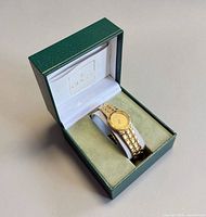 Watch displayed in original green Gucci box