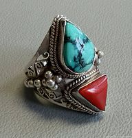 Oblique view showing turquoise and coral stones, rope bezels, beadwork, filigree shank