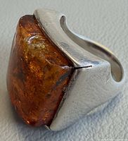 Side view showing amber cabochon and silver setting