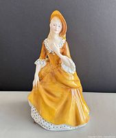 Front view of porcelain figurine in yellow dress
