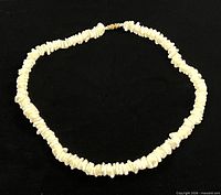 full view of white stone chip necklace laid flat in oval