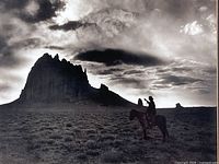Close view of black-and-white image showing Ship Rock and rider