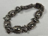 Front view of silver-tone link bracelet showing design elements