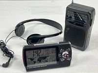 Front view showing all three items: clock displaying time, radio, headphones