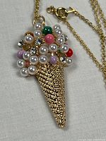 Front view of gold-tone ice cream cone pendant on chain