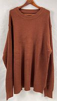Full front view of rust-brown crew neck sweater on hanger