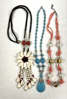 Full view of three necklaces laid flat