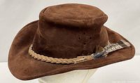 Side view of brown suede bush hat showing band and feather