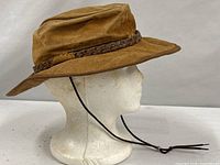 Side view of tan suede outback hat on mannequin head showing chin cord and brim shape