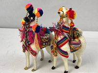 Two multicoloured yarn llama figurines side by side