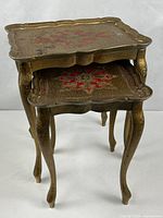 Two gold and red Florentine nesting tables, stacked