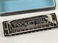 Top view of harmonica in case displaying Pocket Pal and Hohner branding