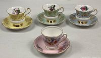 All four cup and saucer sets displayed