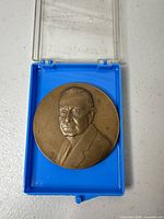 Obverse portrait of bronze medal in blue plastic case