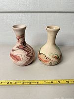 Front view of both marbled bud vases side by side with ruler for scale