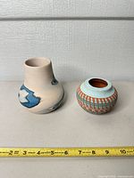Two small vases with ruler showing scale