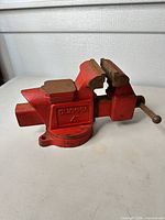 Full view of Olympia red cast iron 4" bench vise on swivel base