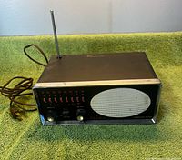 Front view showing controls, speaker grille, antenna, power cord