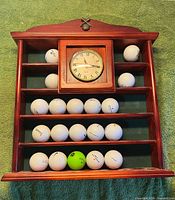 Full view of wood rack with clock and golf balls