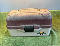 Front view of tackle box showing paint overspray and Flambeau logo
