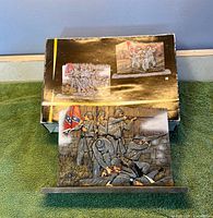 Front of plaque and box showing battle scene artwork