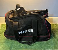 Front view of Husky bag showing logo, handles, red trim