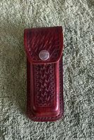 Front view of brown leather pouch with basketweave pattern and snap