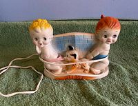 Front view of ceramic night light with figures and cord