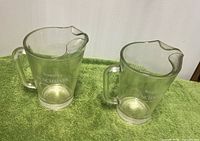 Two Seagram's Benchmark pitchers side view