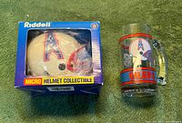 Front view of boxed micro helmet next to Oilers glass mug