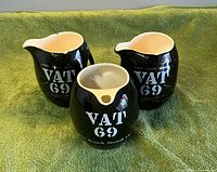 Front view of three VAT 69 black ceramic pitchers