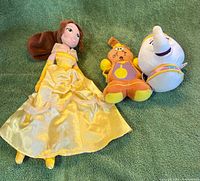 Front view of three plush toys on green surface