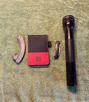 All four items laid out: spanner wrench, memo pad holder, pocket knife, MagLite flashlight