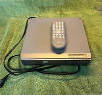 Top view of Magnavox MWD200F DVD player with remote placed on top, power cord visible