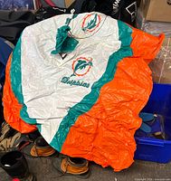Poncho spread out showing hood, large team logo, orange sides