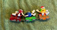 Front view of three linked train cars with M&M characters