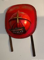 Front view of red firefighter helmet decor showing shield text and straps