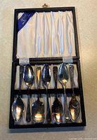 Open case displaying six spoons